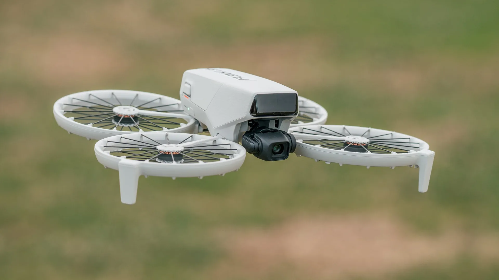 En primer plano el DJI Flip volando y de fondo un campo