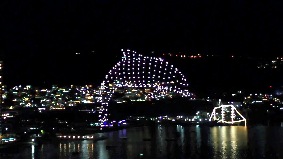 Drones formando un delfin en las costas de Acapulco, de fondo la luces de la ciudad
