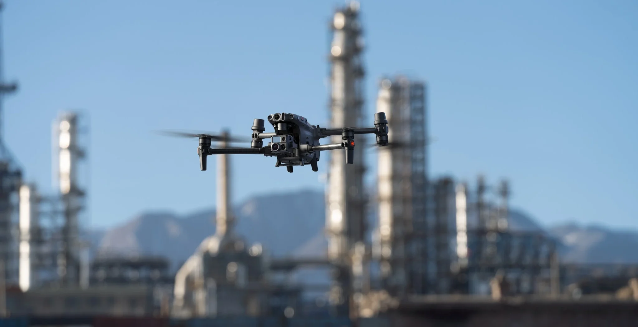 Imagen en primer plano del DJI Matrice 30 y de fondo una planta quimica