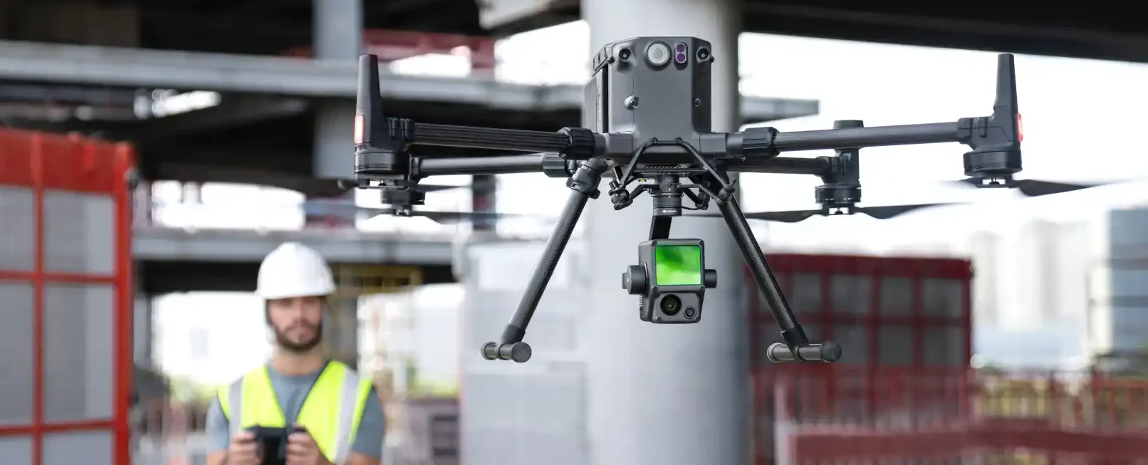 Imagen de un DJI RTK 350 volando en una construcción y de fondo un piloto