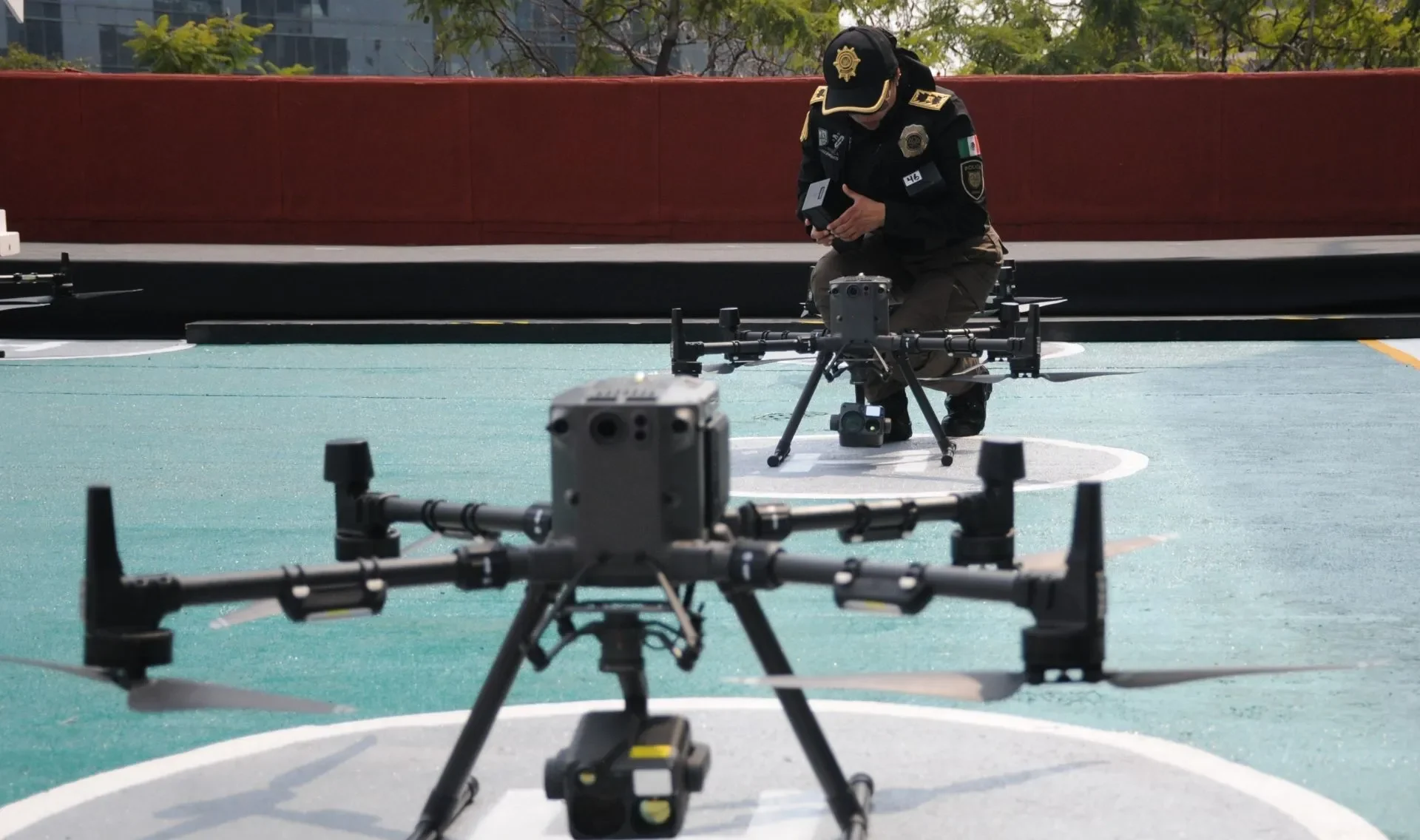 Imagen de dos M350 RTK apunto de despegar y una policia de fondo
