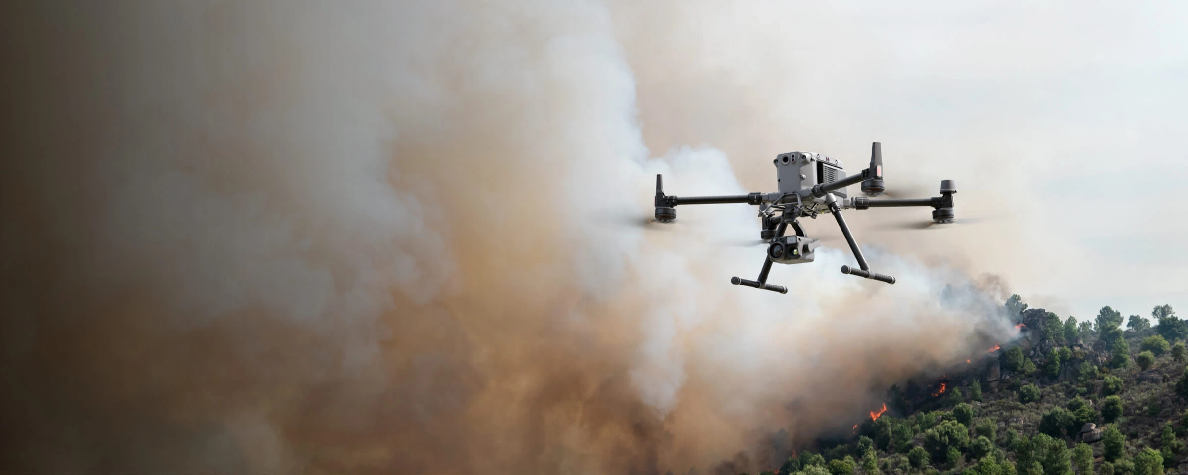 Primer plano un DJI un DJI M350 y de fondo un incendio forestal "Drones en Zonas Difíciles"