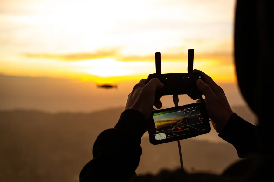 Operador controlando dron y monitoreando datos en pantalla en tiempo real durante vuelo